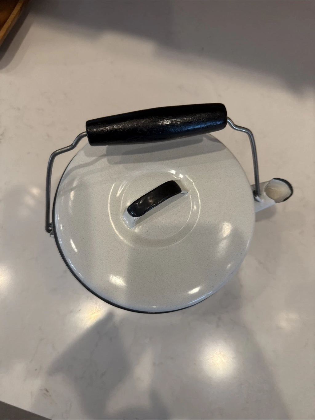 vintage enamel tea kettle with a wood handle, dating from the mid-20th century.