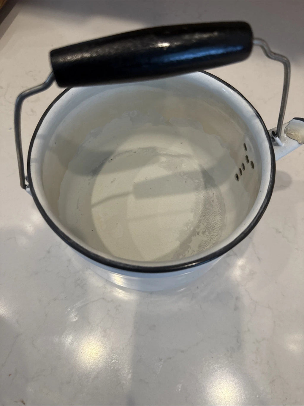 vintage enamel tea kettle with a wood handle, dating from the mid-20th century.