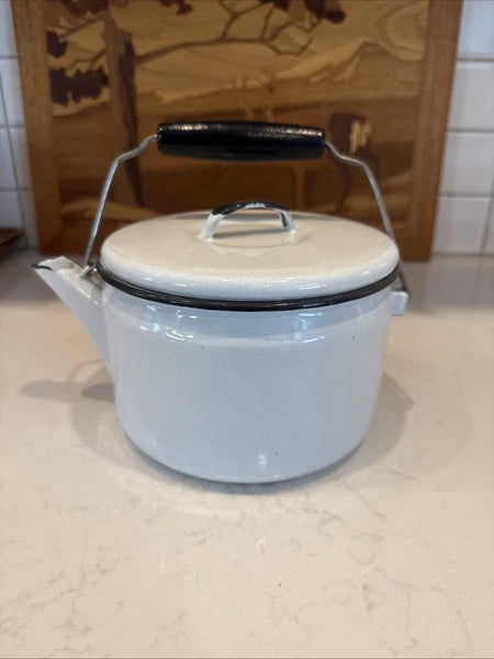 vintage enamel tea kettle with a wood handle, dating from the mid-20th century.