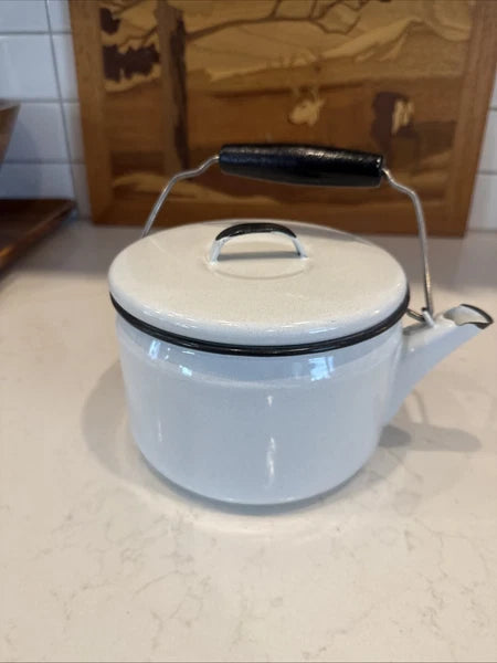 vintage enamel tea kettle with a wood handle, dating from the mid-20th century.
